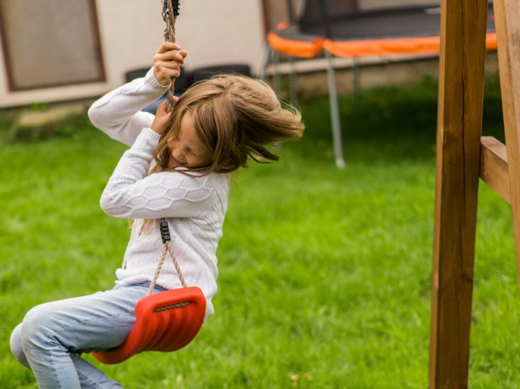 Mädchen auf der Schaukel im Garten